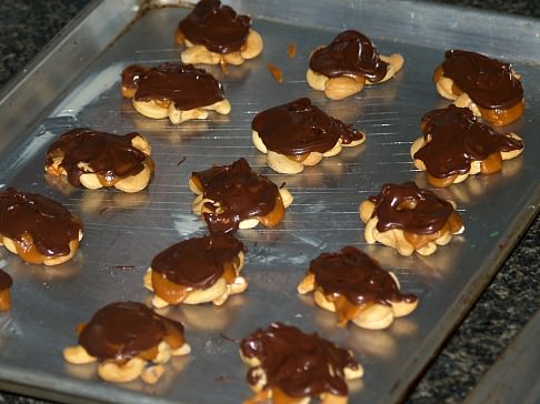 Melted Chocolate Spooned Over Cashews and Cream Mixture