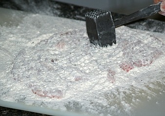 pounding out chicken for a Chicken Picatta Recipe